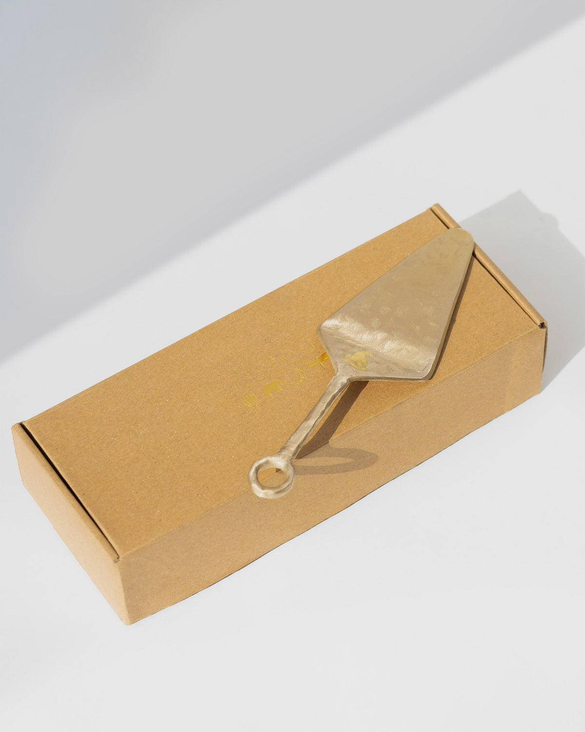 Celeste Spatula resting across a kraft box.