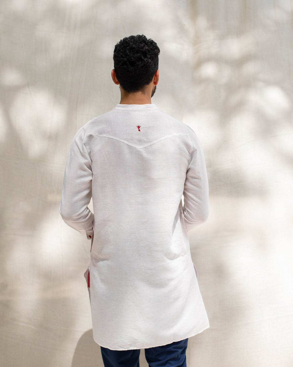 Back of the Pondicherry Kurta worn by a person, with a small red motif at the yoke.