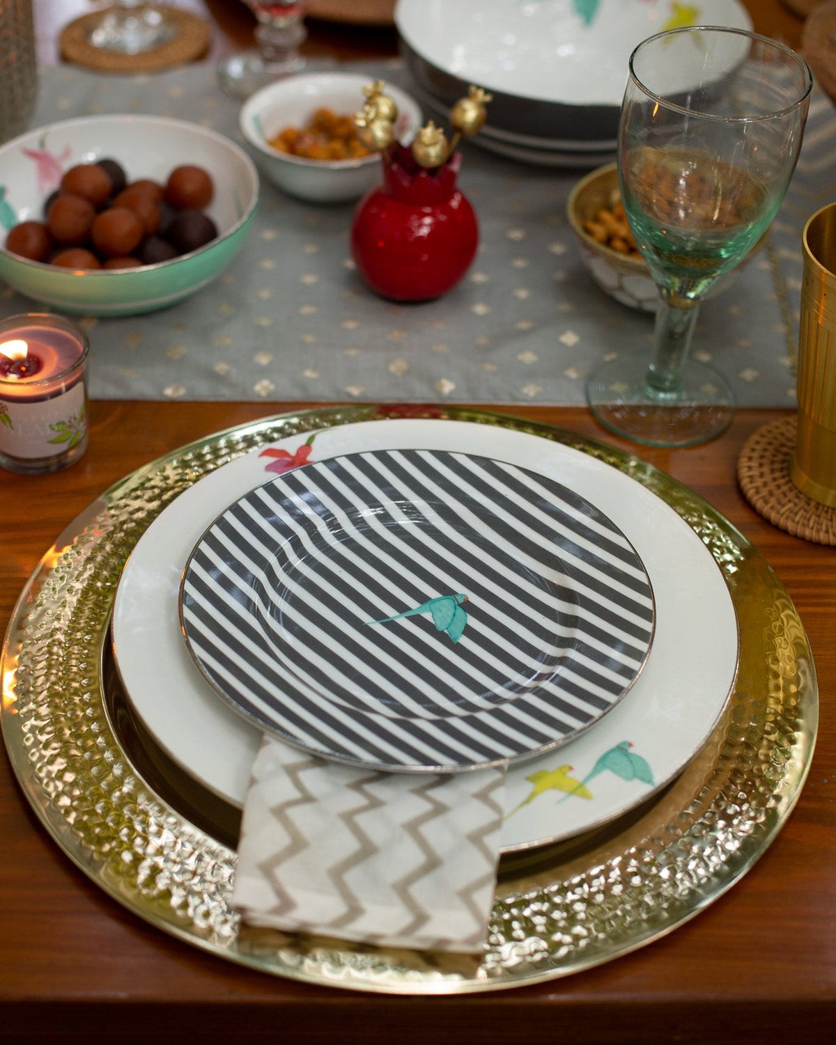 Botanical Dinner Plate set on a gold charger at a dinner table.