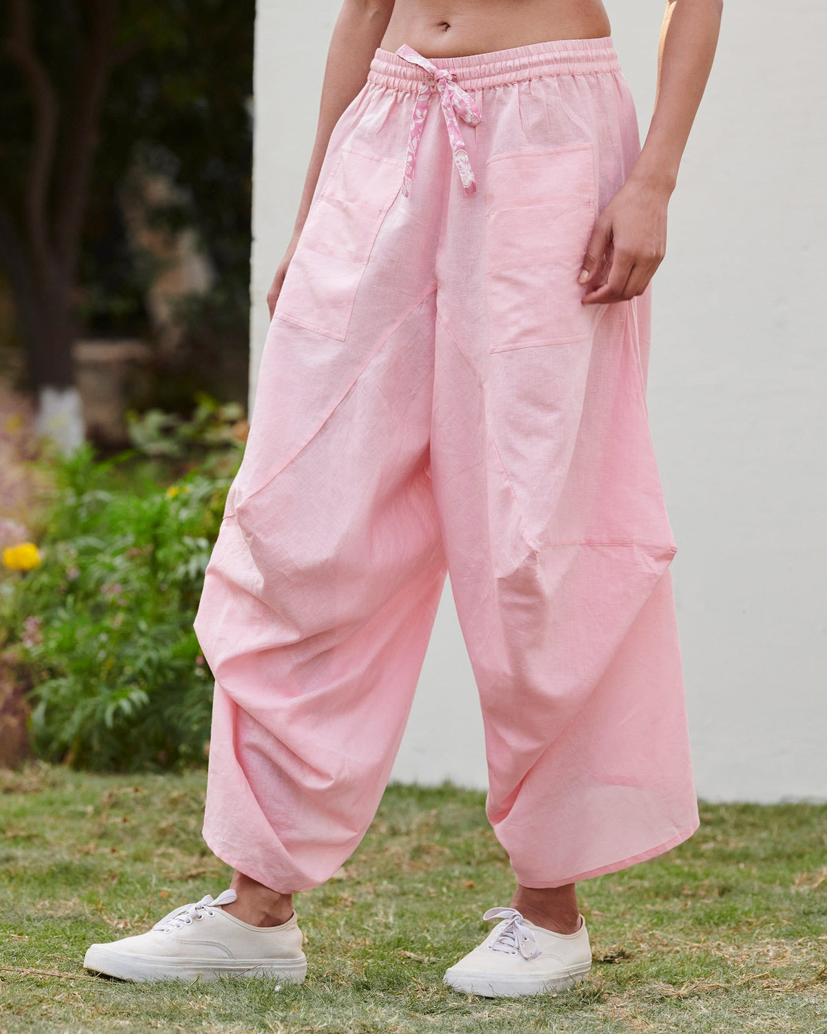 Side view of Yoka Trousers in pink worn by a person.