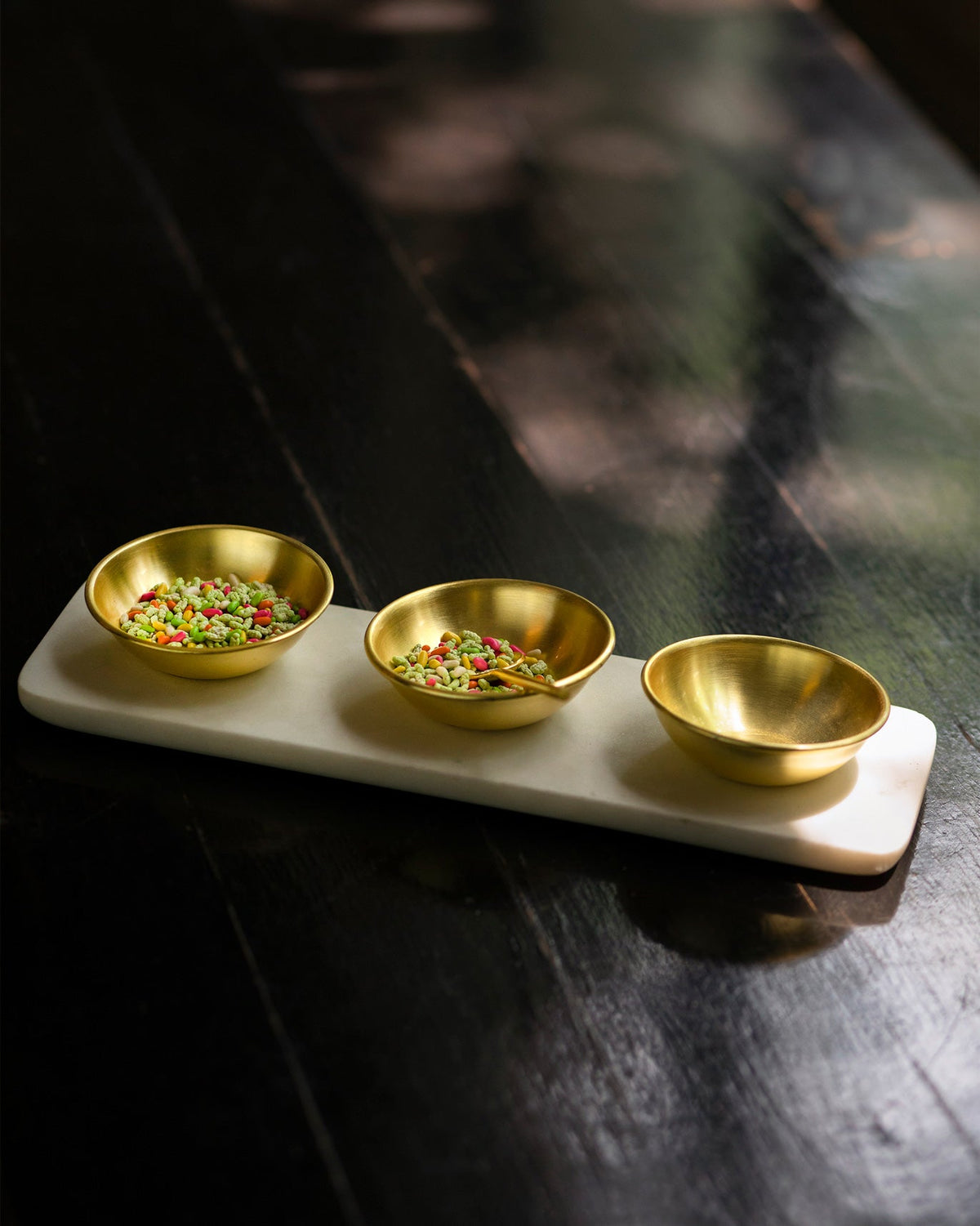 Dariya Tray Set with three brass bowls, two filled with coloured seeds.