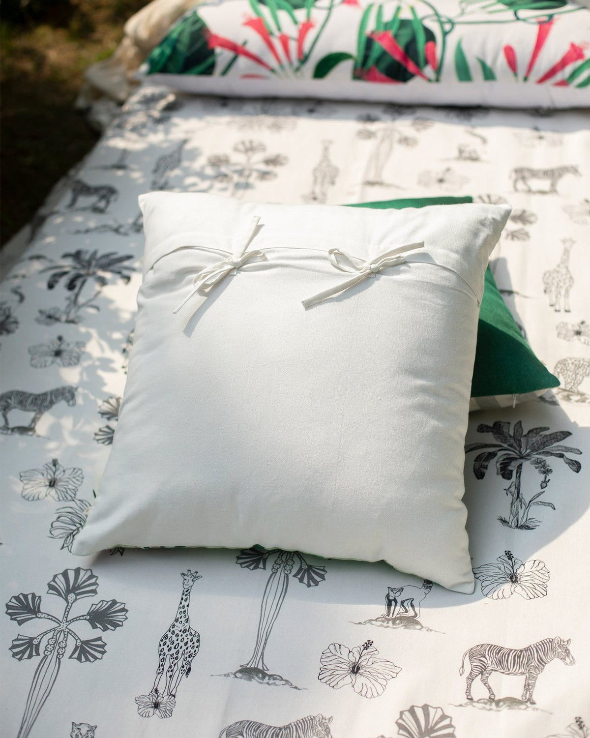 Idukki Cushion Cover in plain white with ribbon ties at the centre.
