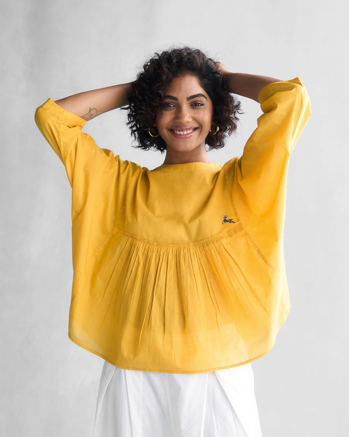 Person wearing the Bougainvillea Sleeve Top in ochre with wide sleeves.