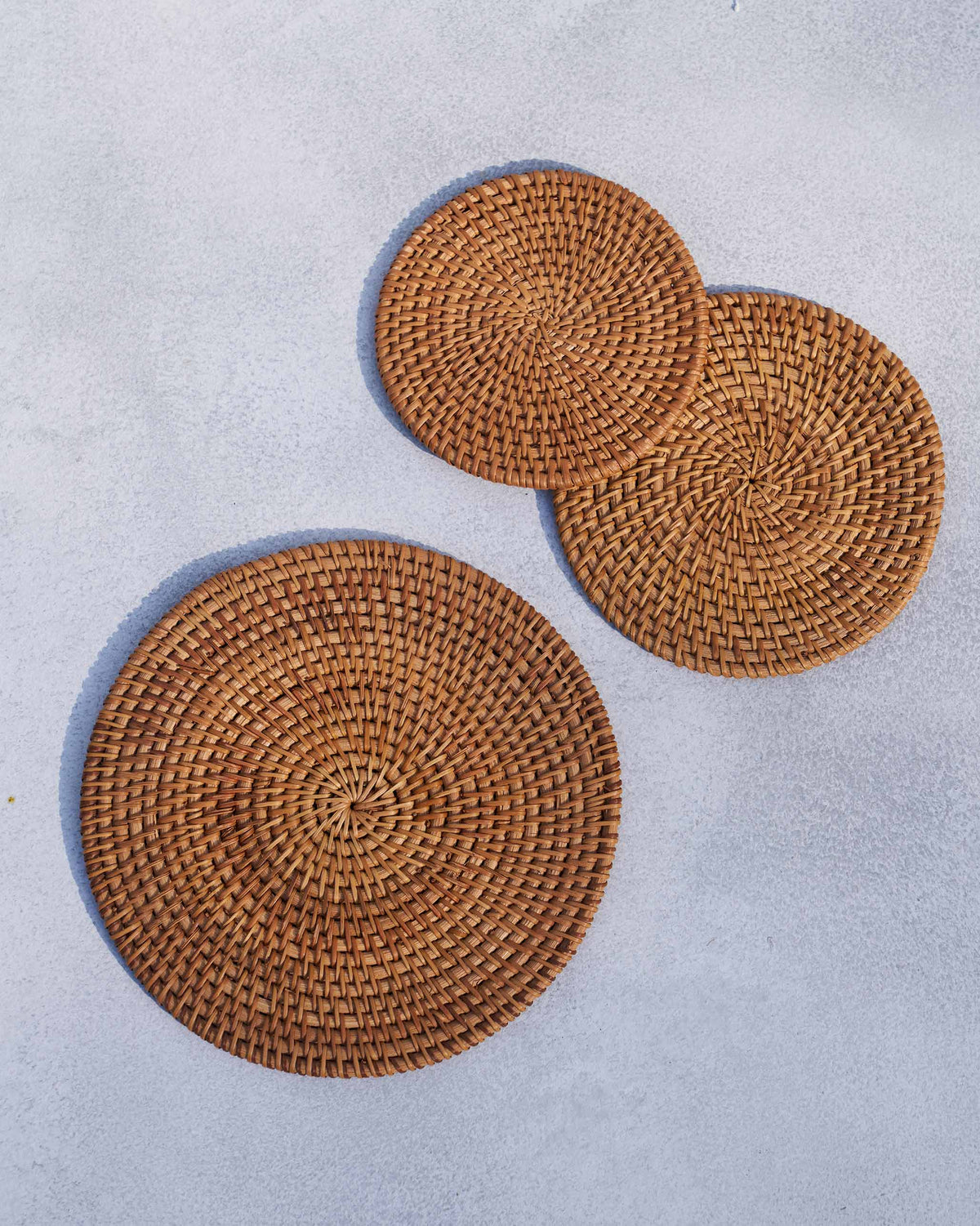 Three Rattan Trivets arranged in a loose group.