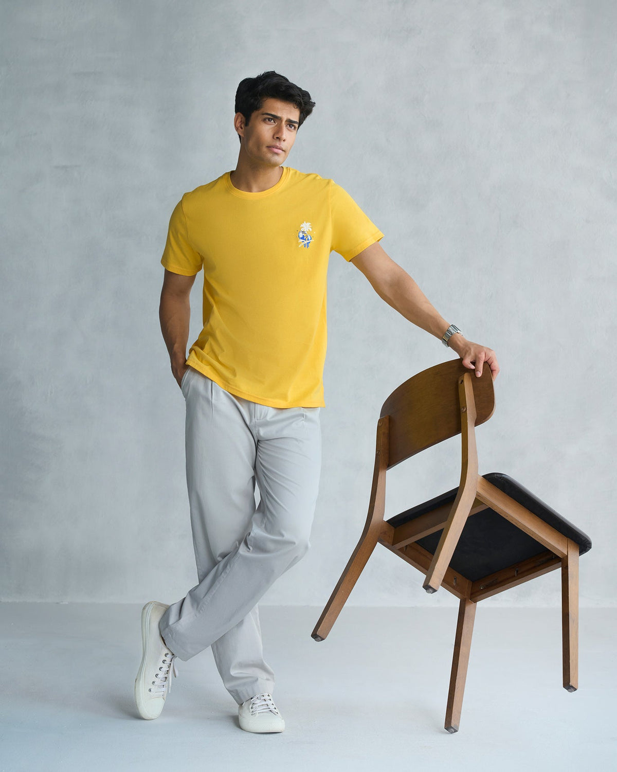 Full-length view of a yellow Toucan T-shirt worn by a person.