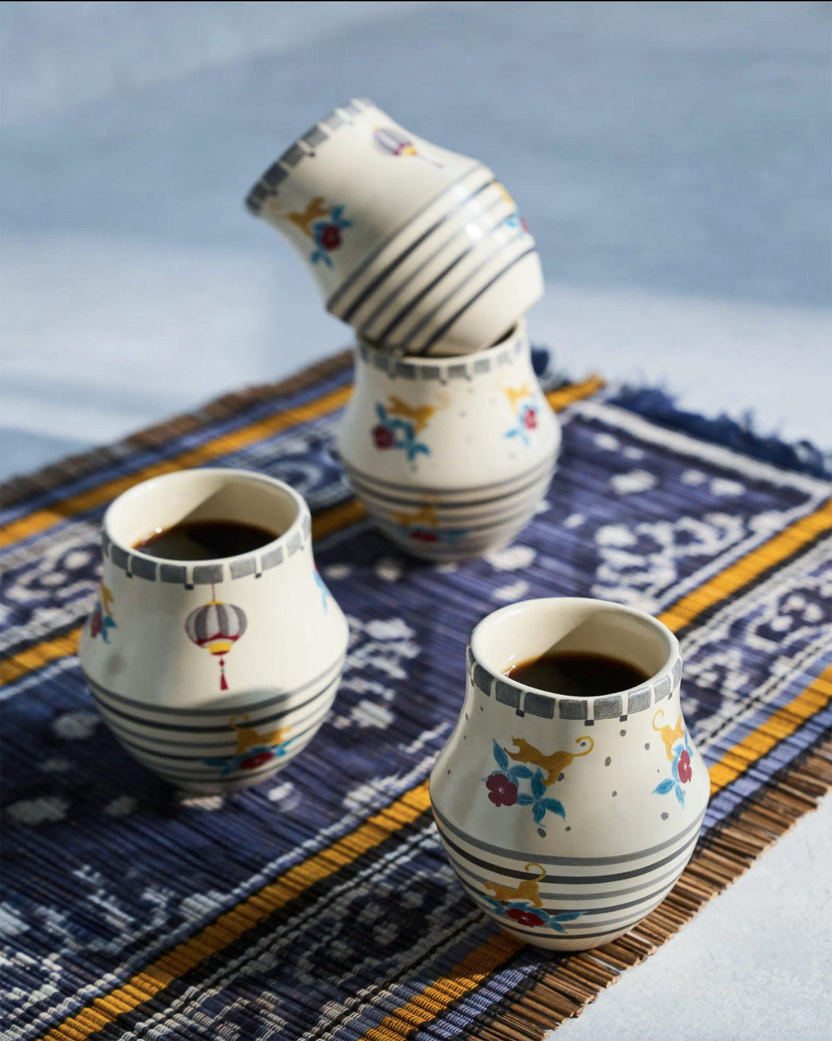 Phoenix kulhar cups on a blue patterned mat.