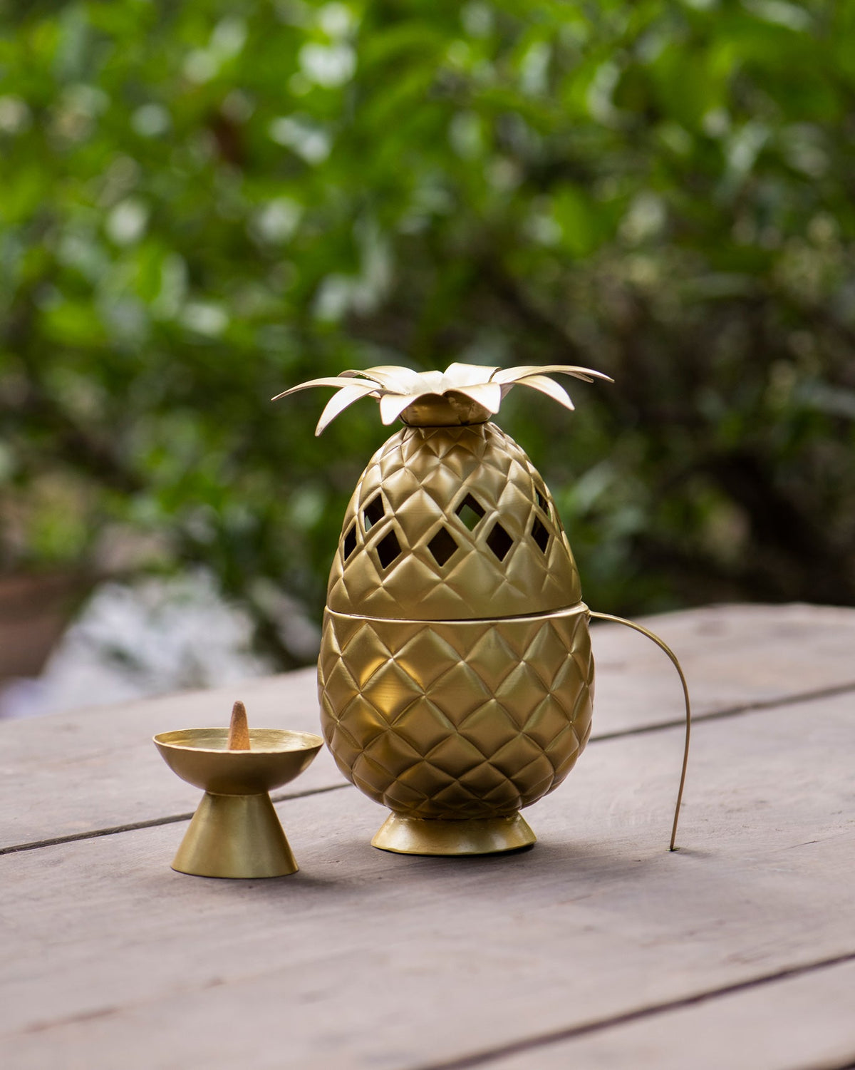 Side view of Ananas dhuna showing its curved handle and cut-out pattern.