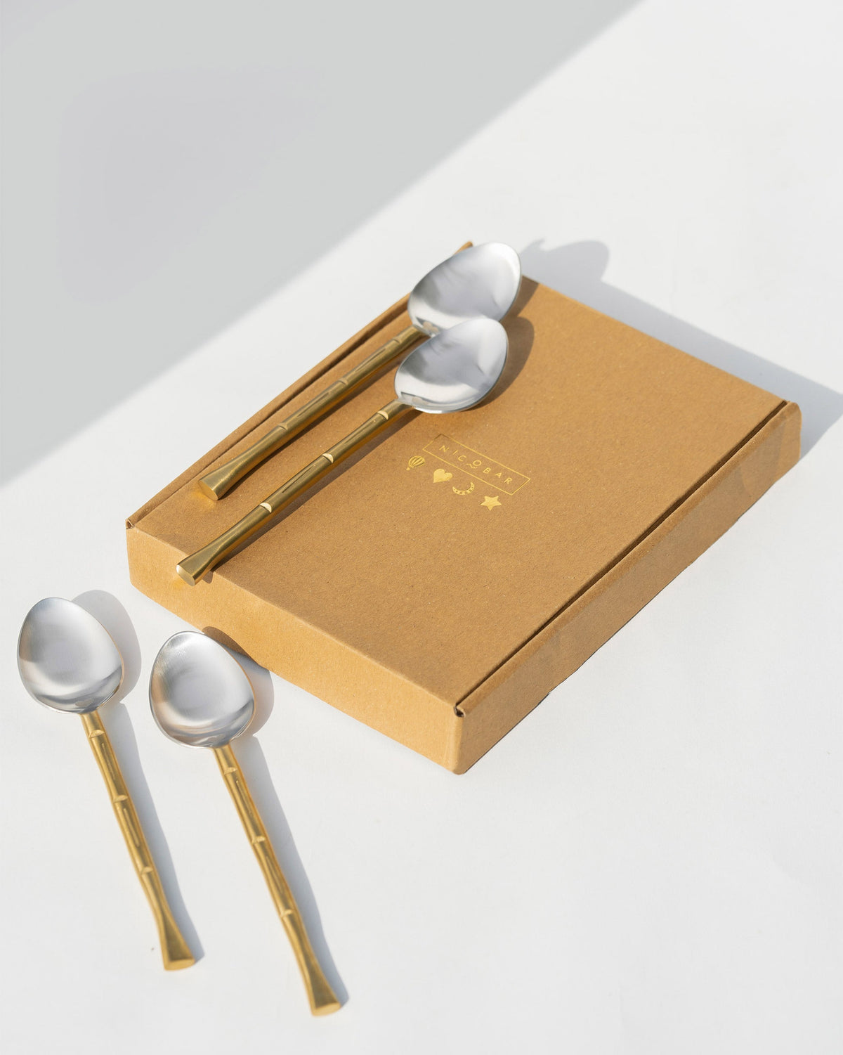 Horizon Spoon (Set of 4) laid beside a kraft gift box.