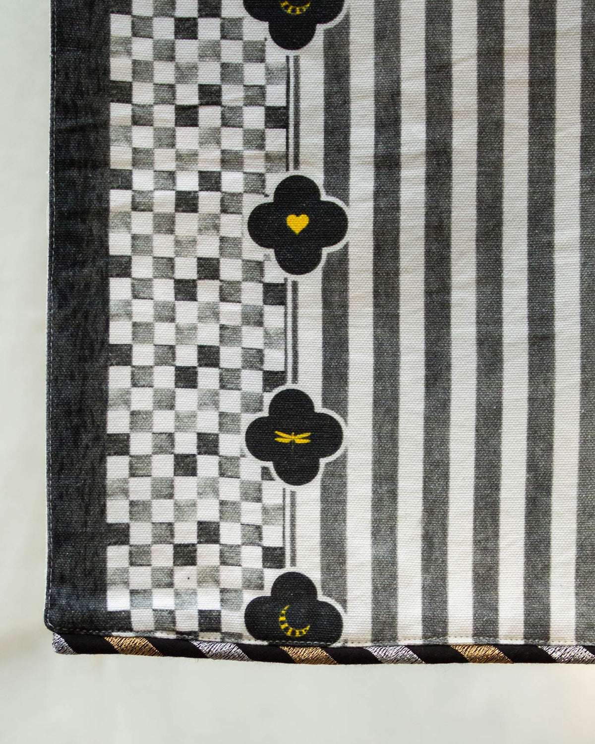 Close-up of the Midnight Runner showing black clover motifs beside checked and striped bands.