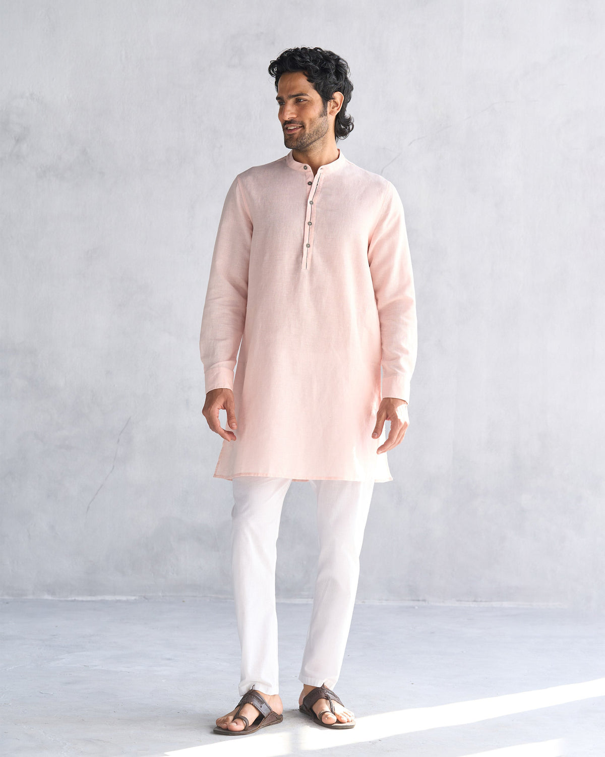 Person wearing a mid-thigh pink Chandni Chowk kurta.