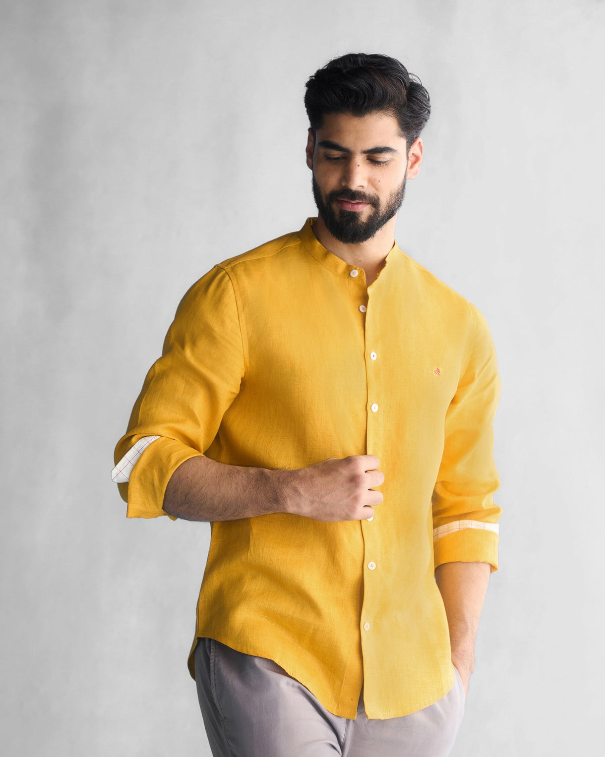 Person wearing an ochre Nawab shirt, hand at the placket.