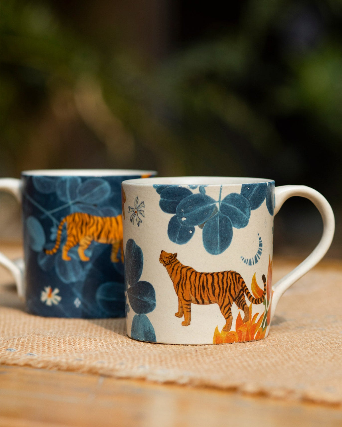 Pair of Nadi straight mugs in cream and navy with matching tiger prints.