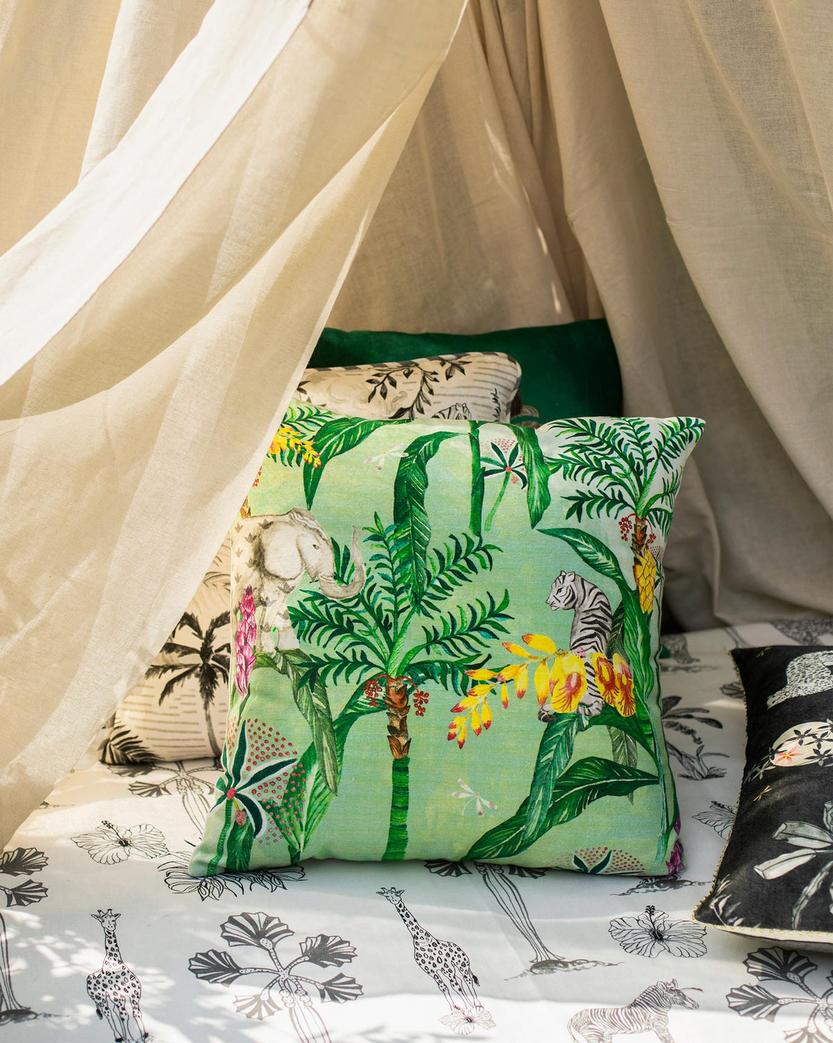 Idukki Cushion Cover with a green jungle print of palms and a zebra.