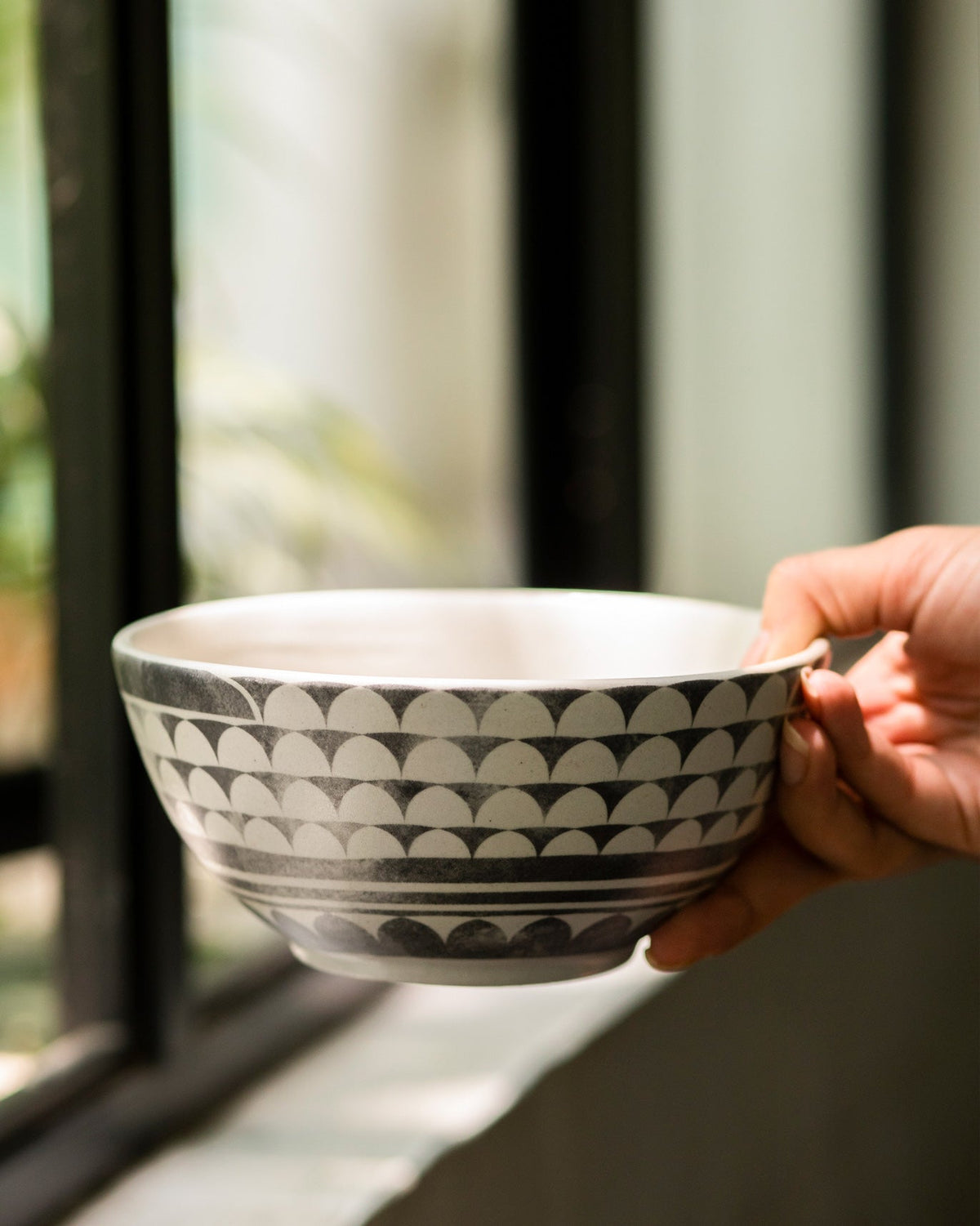 Person holding the Aasma Curry Bowl with its grey scalloped band.