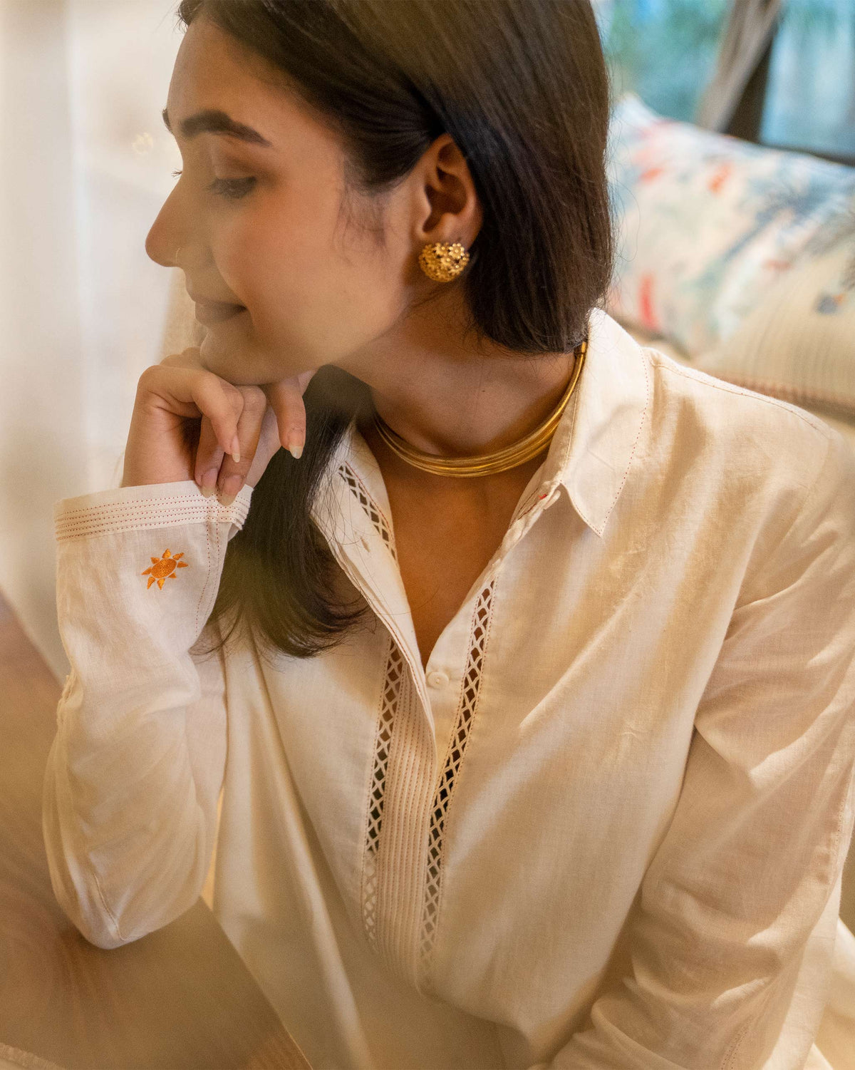 Close-up of the Back Flayer Top placket with eyelet trim and an orange star on the cuff.