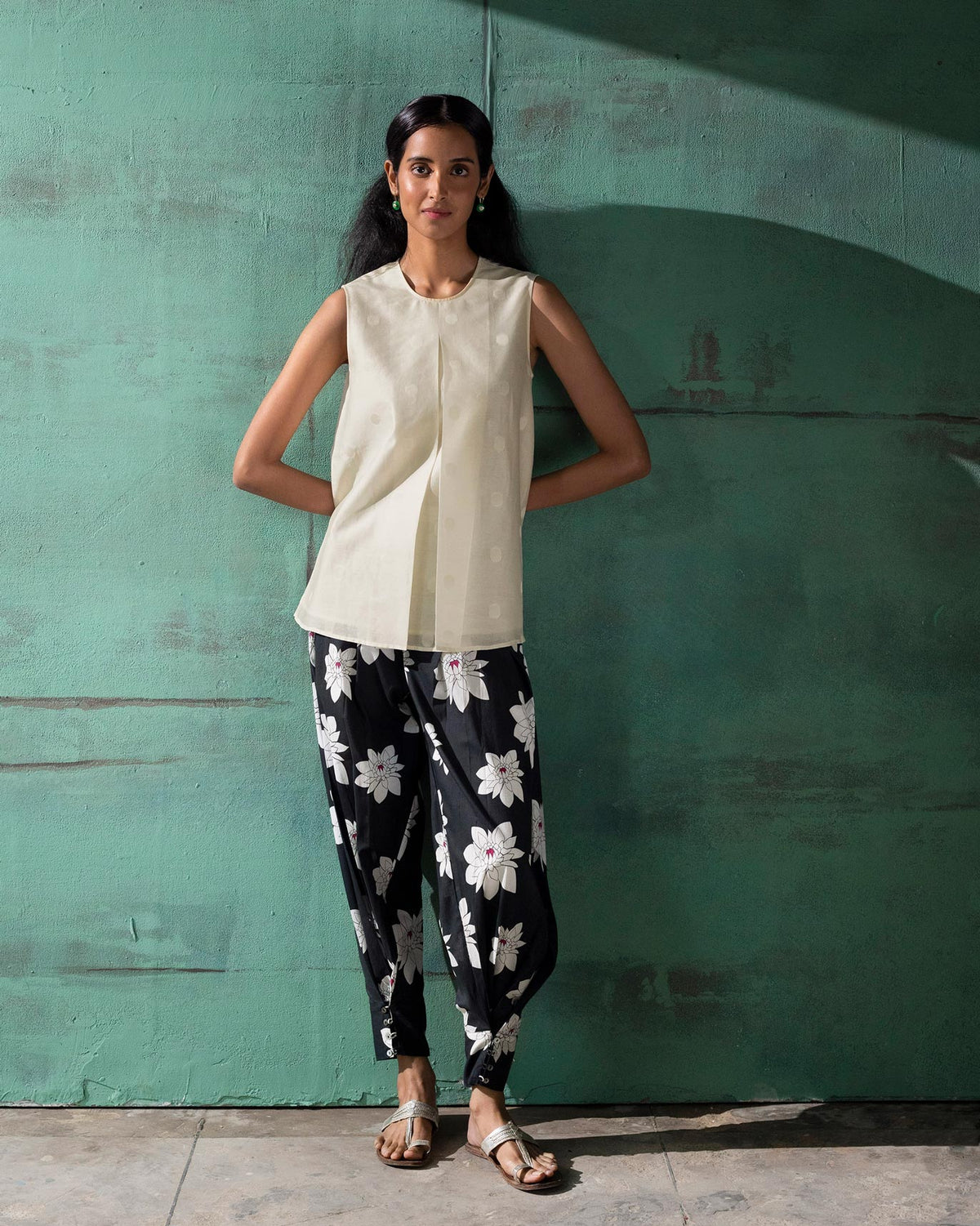 Full-length view of an ivory sleeveless A-line top worn by a person.