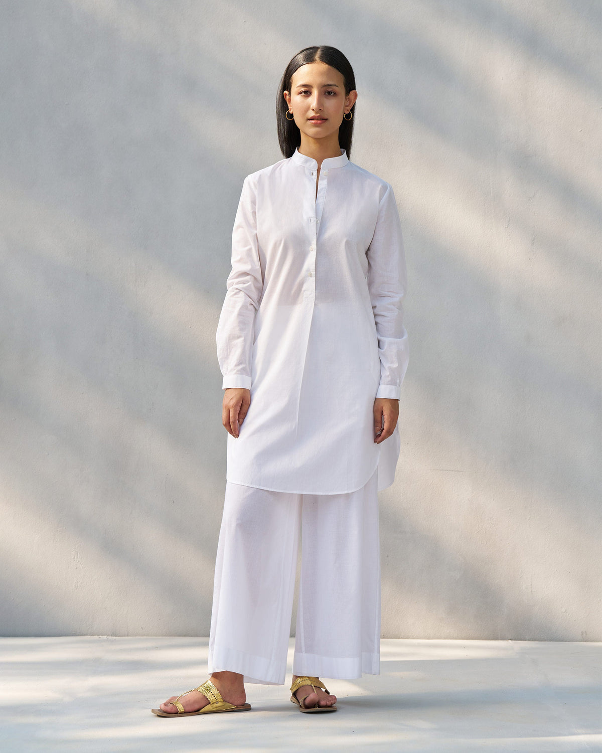 Person wearing a white Moon set tunic and matching wide pants.