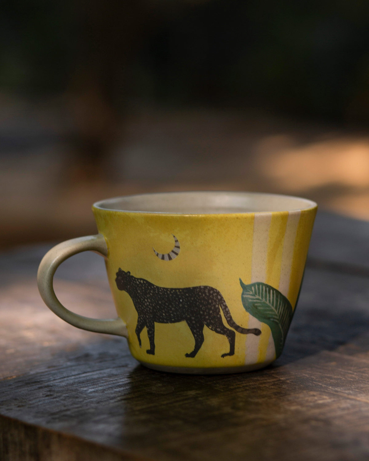 Leopard Soup Mug in yellow with a leopard and a leaf, handle on the left.