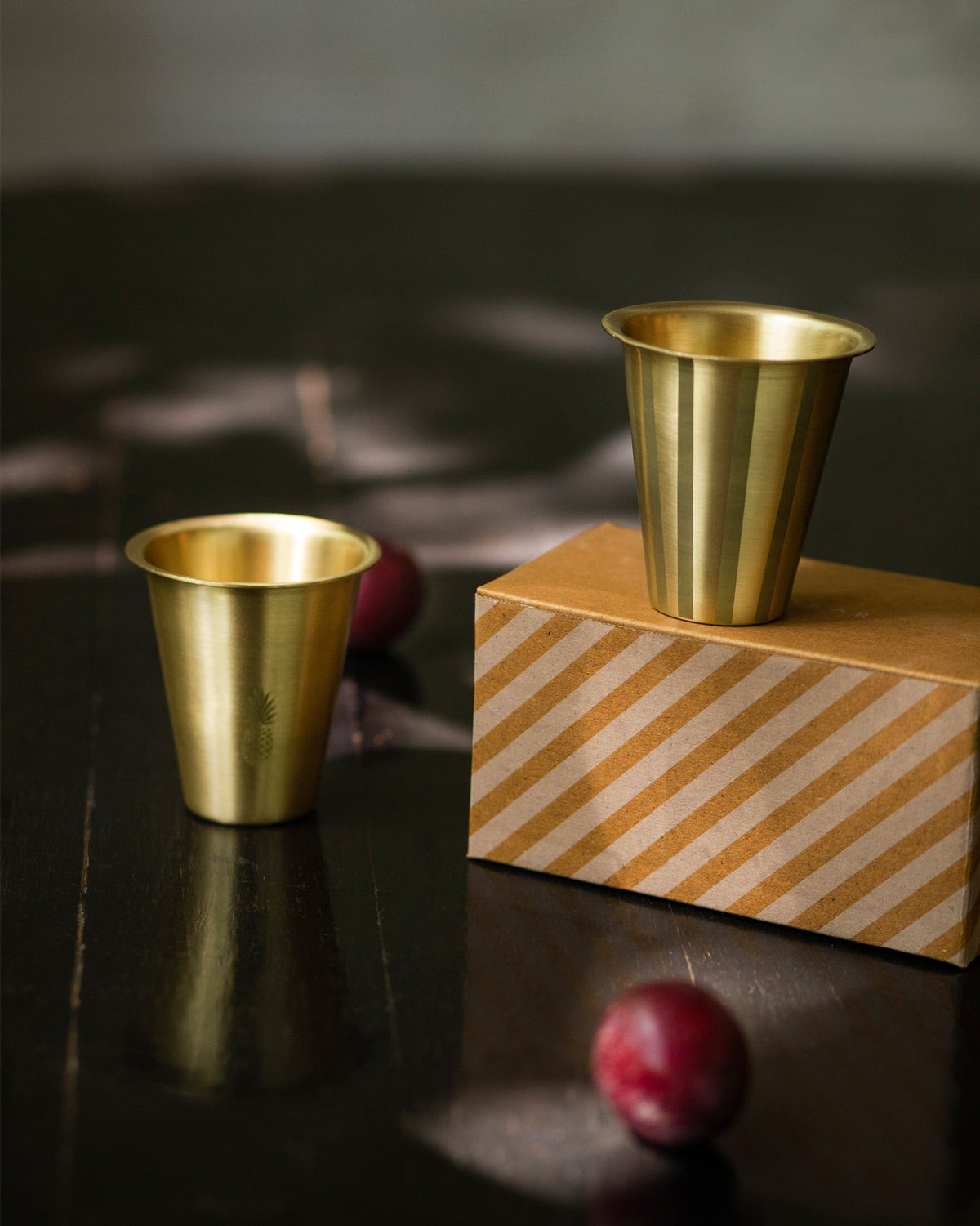 Dariya Tumblers standing on a striped box, one with a small pineapple motif.
