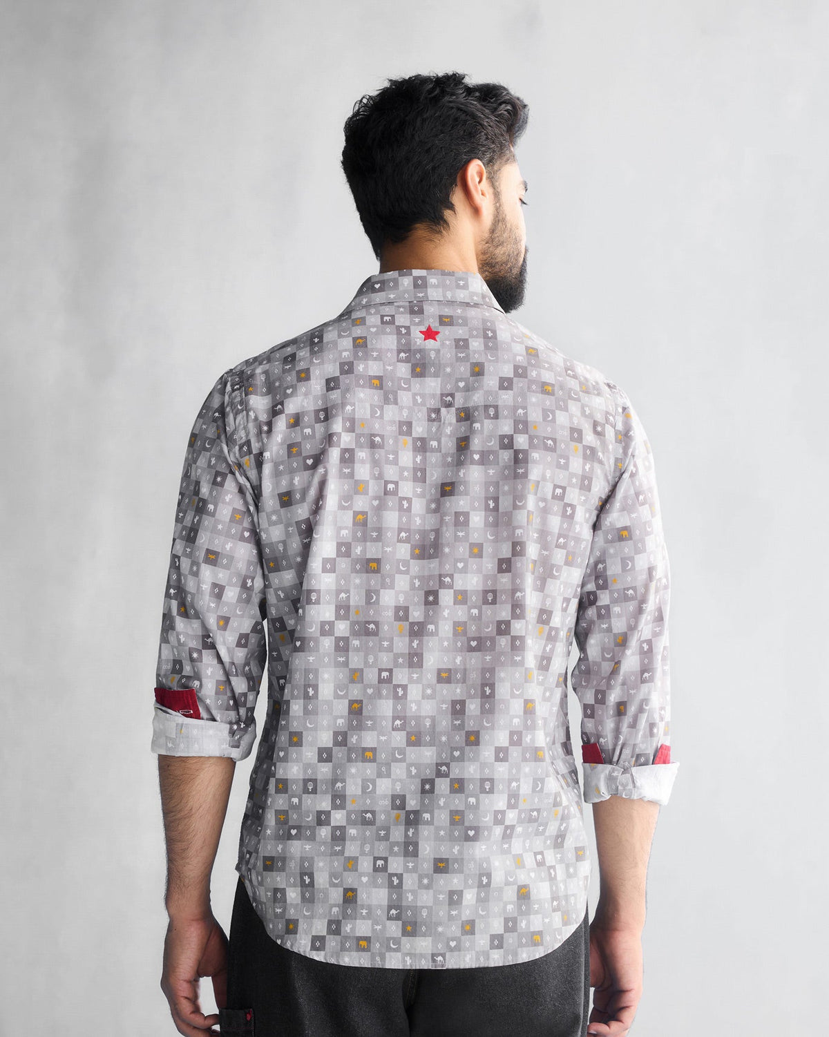 Back of a grey Pocket Shirt with a small red star worn by a person.