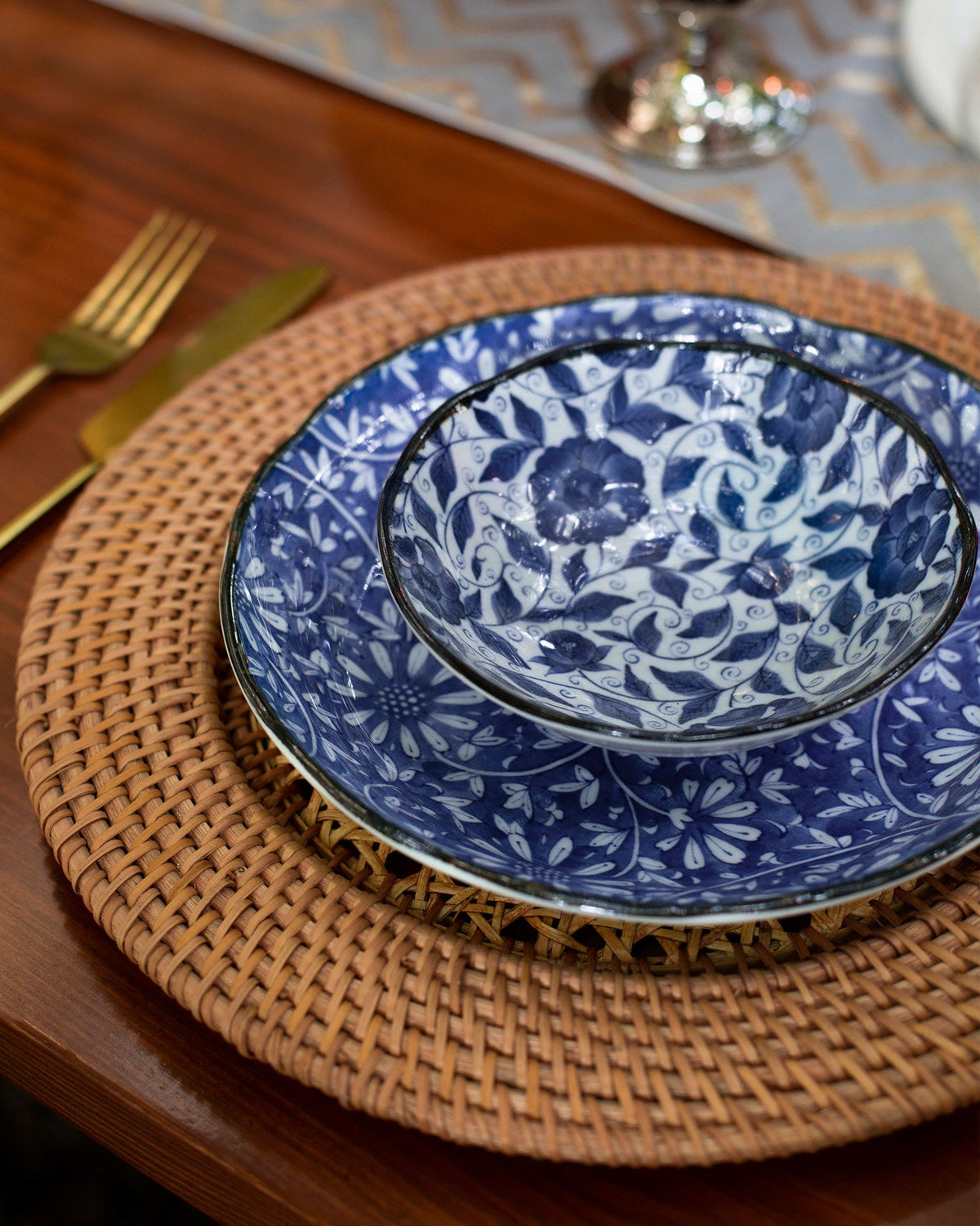 Aika Dessert Bowl nested inside a larger blue floral plate.