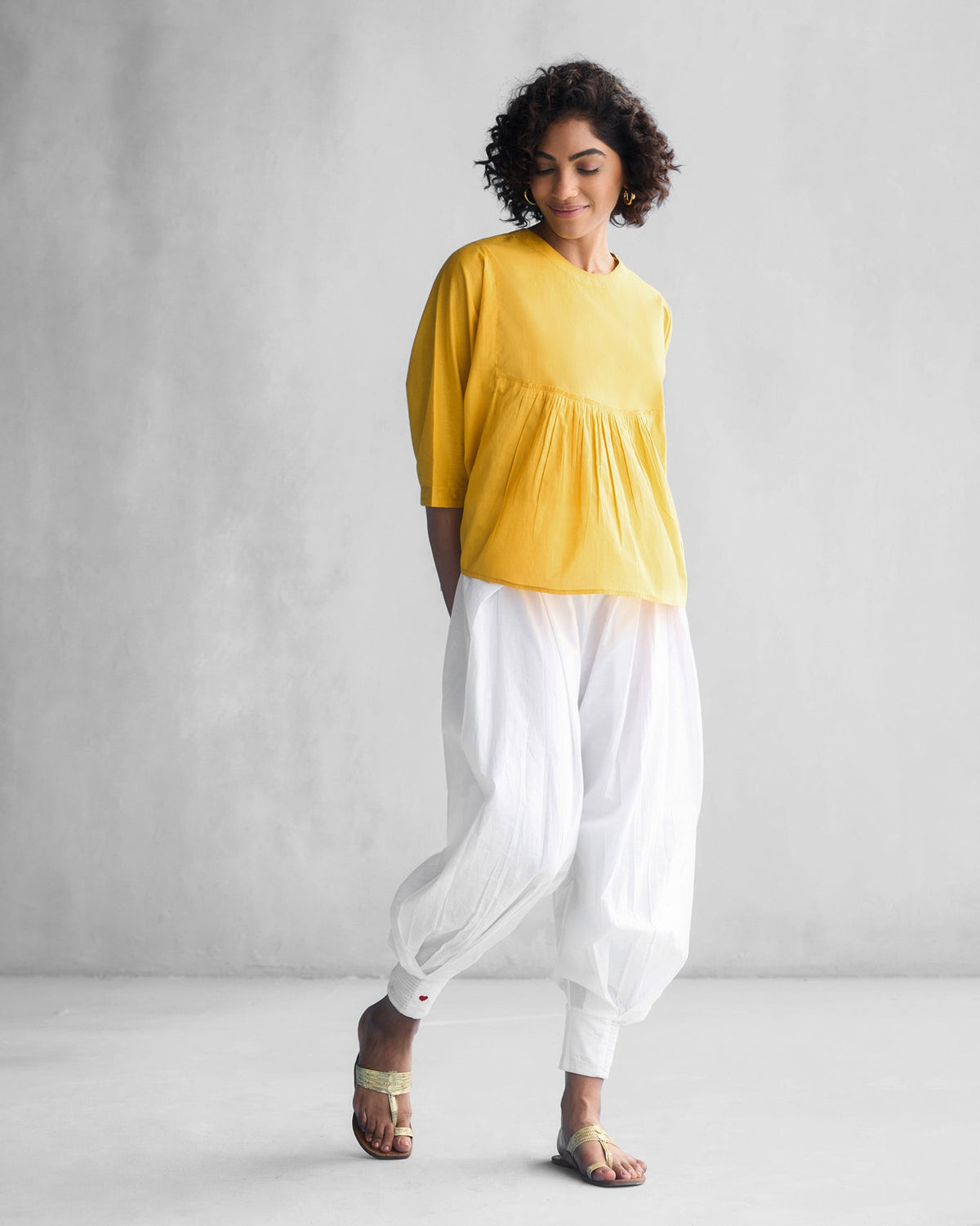 Person wearing the Bougainvillea Sleeve Top in ochre, shown full length.