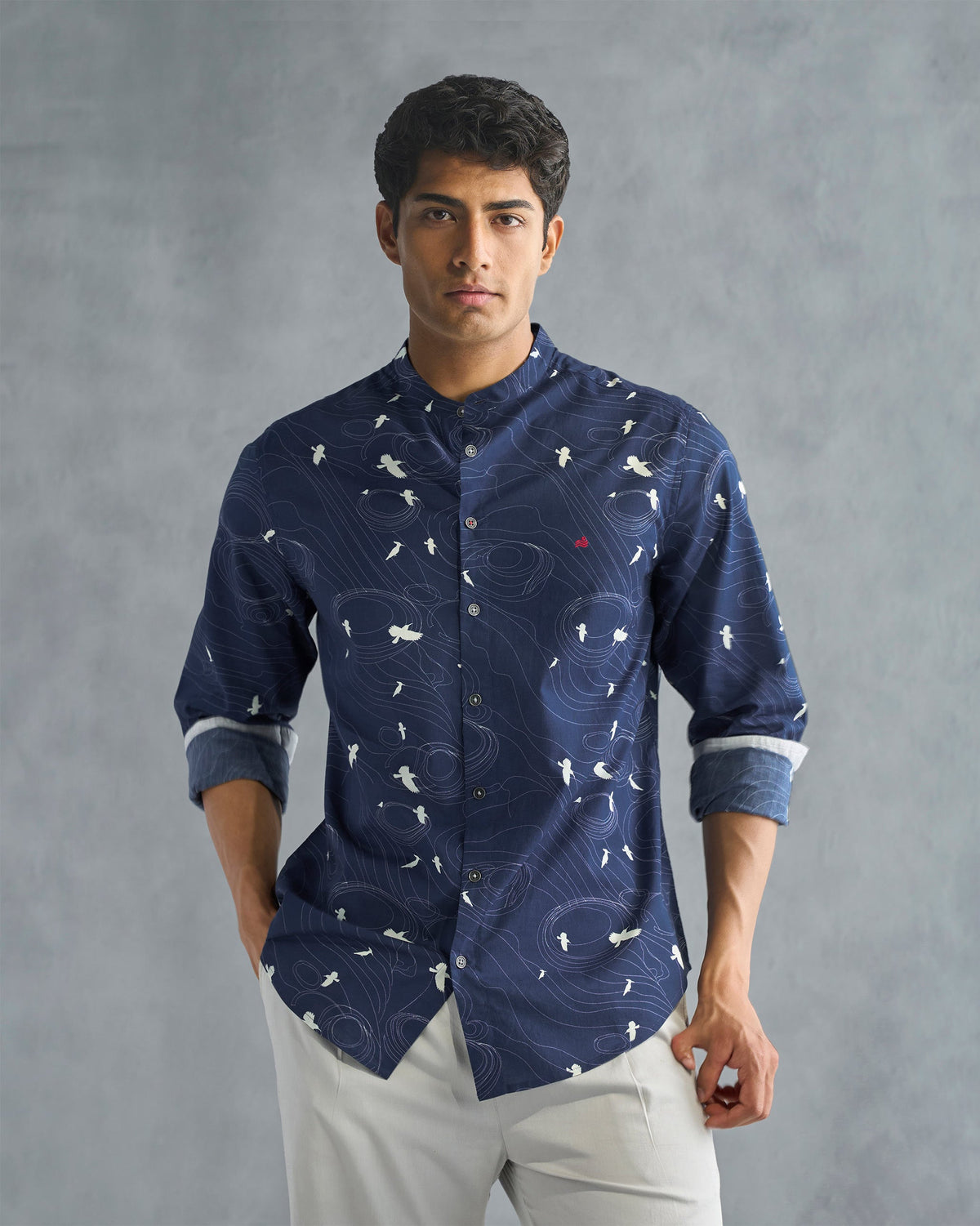Person wearing a deep navy Nawab shirt with a white bird print, arms relaxed.