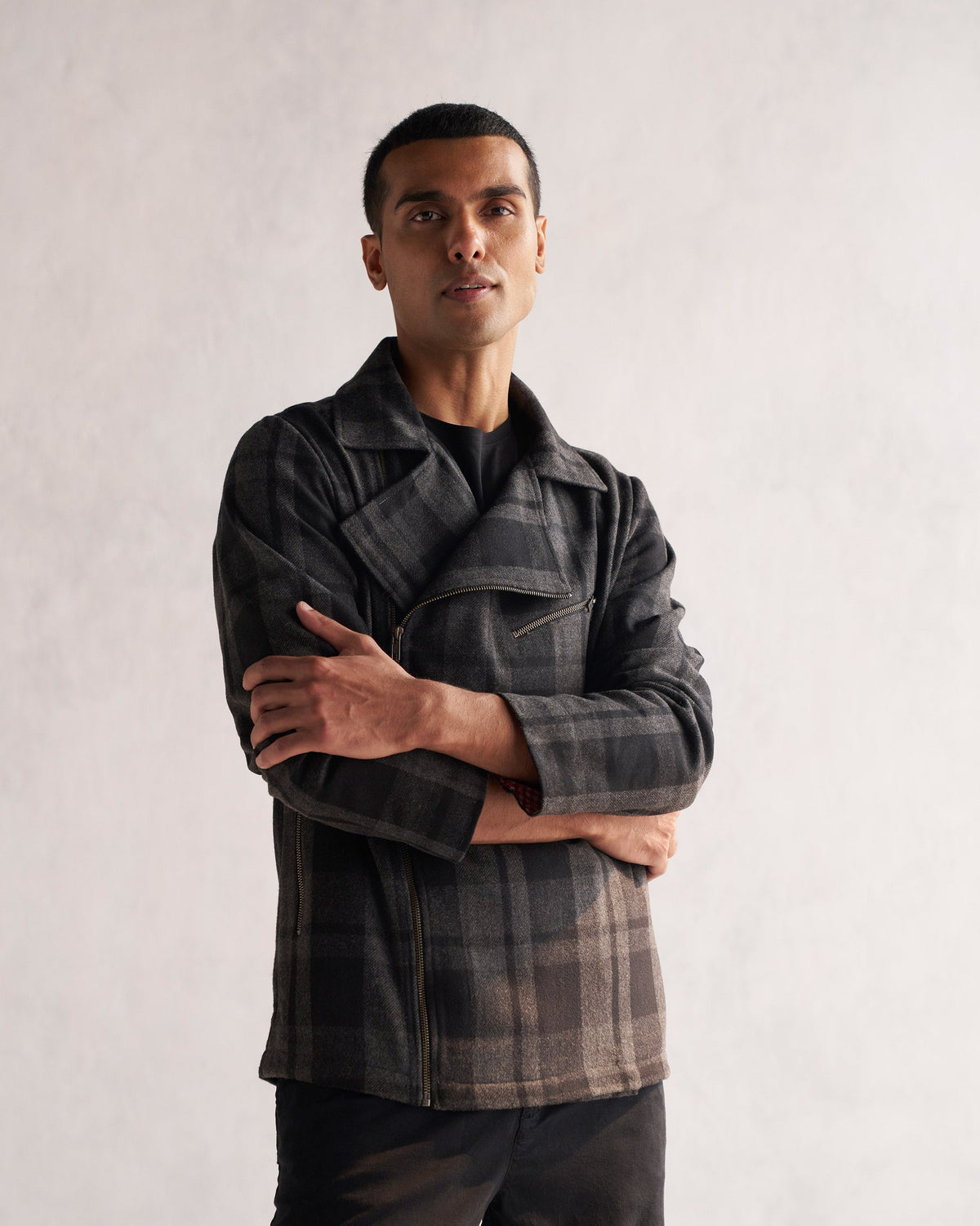 Person standing with arms crossed, wearing a black and grey checked Woollen Knotch Collar Jacket.