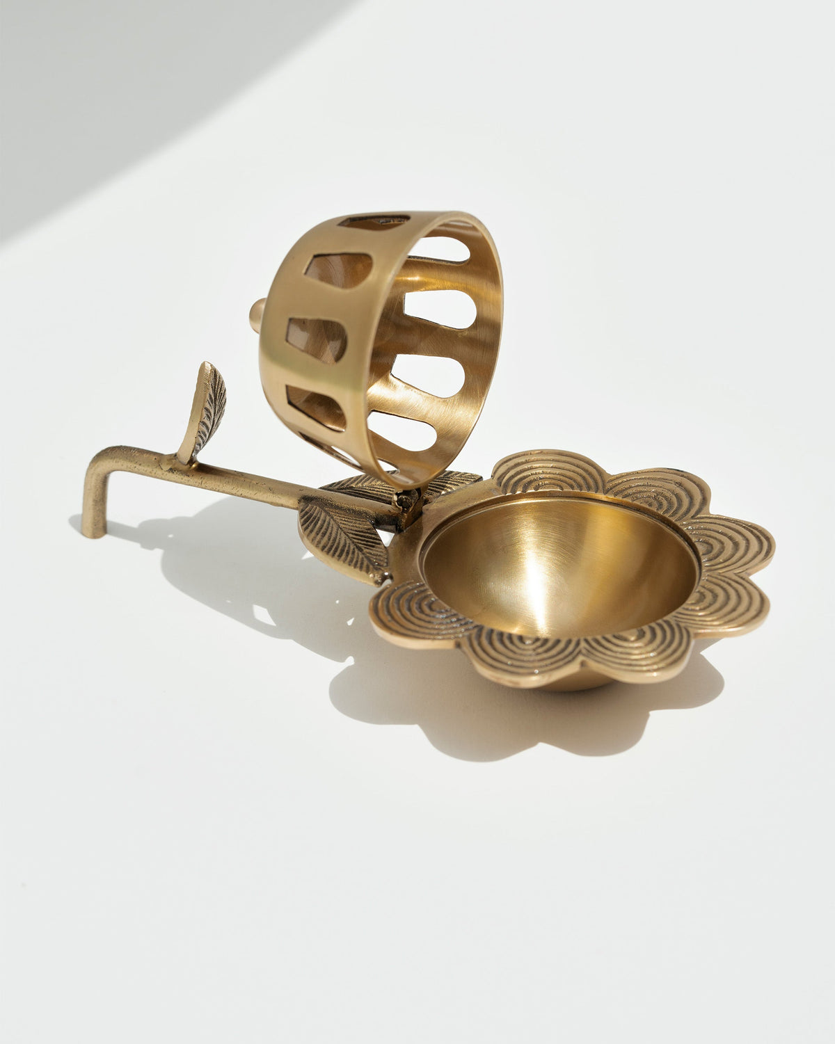 Alpine Dhuna in brass with its dome lifted off, showing the scalloped bowl.