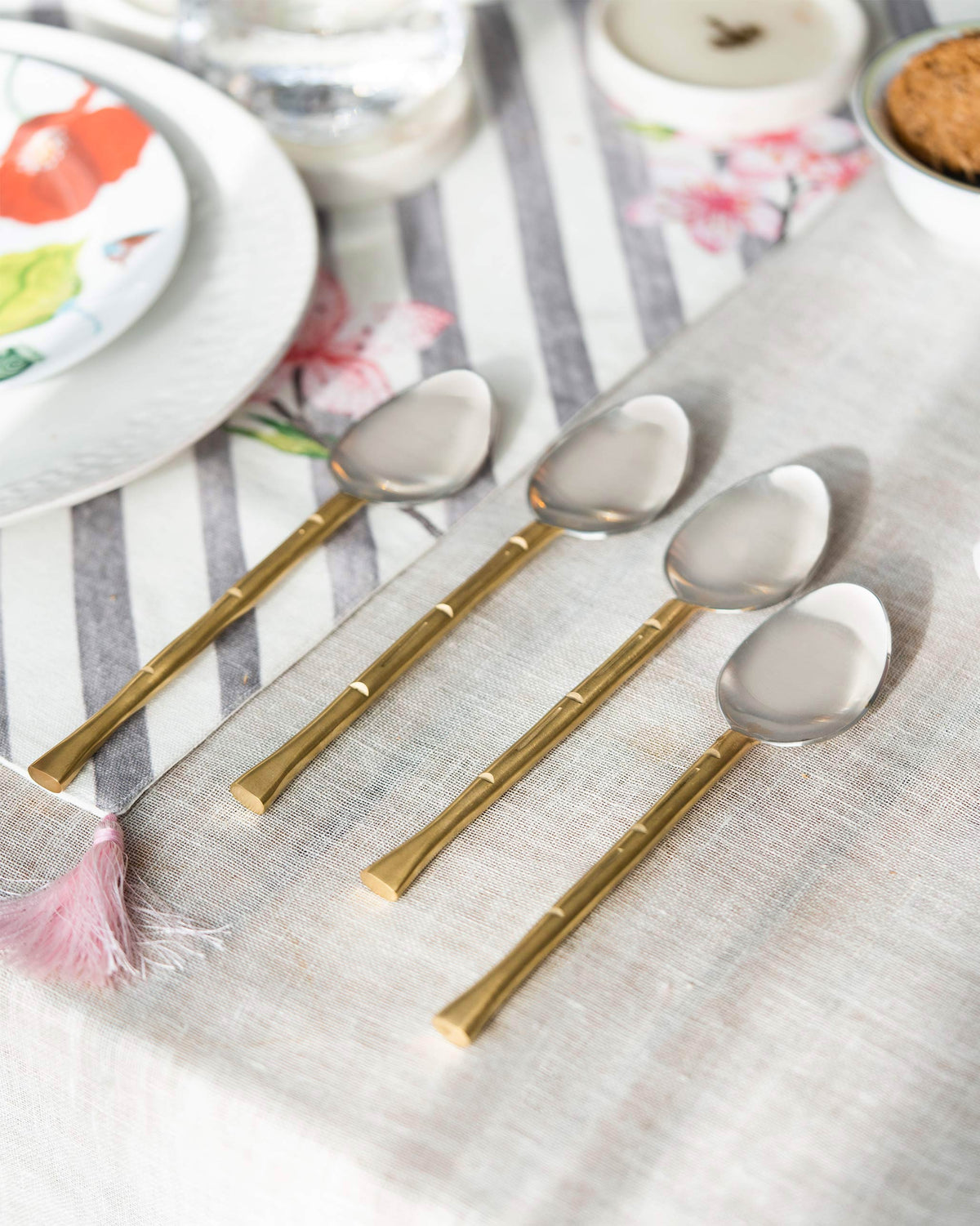 Horizon Spoon (Set of 4) laid across a linen table runner.