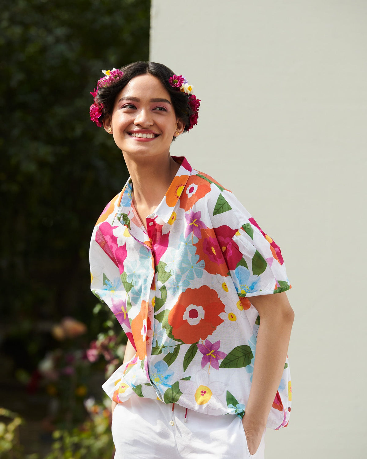 Person wearing a short-sleeve Cord Shirt with vivid multicolor florals.