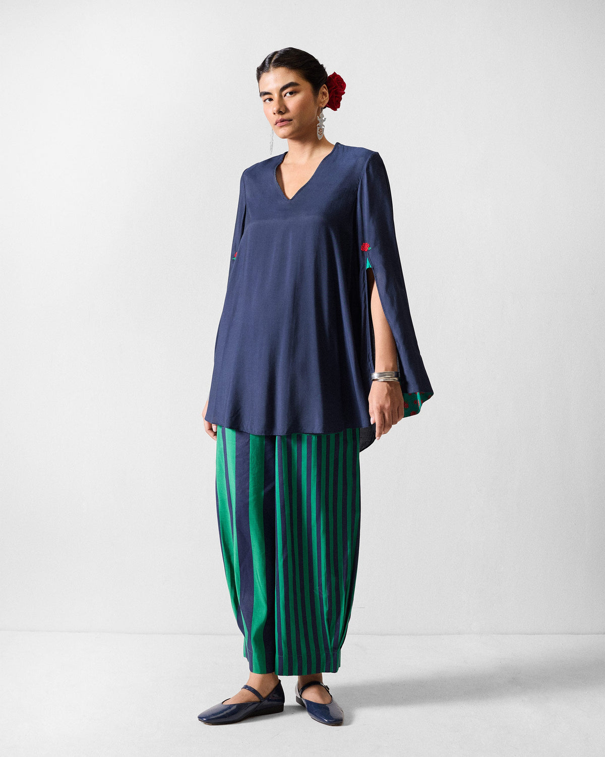 Person wearing a navy Panaji set with split sleeves and wide striped pants.