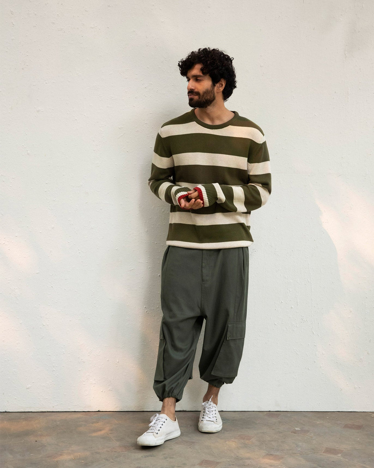 Person standing full length in an olive and oatmeal Round Neck Sweater.