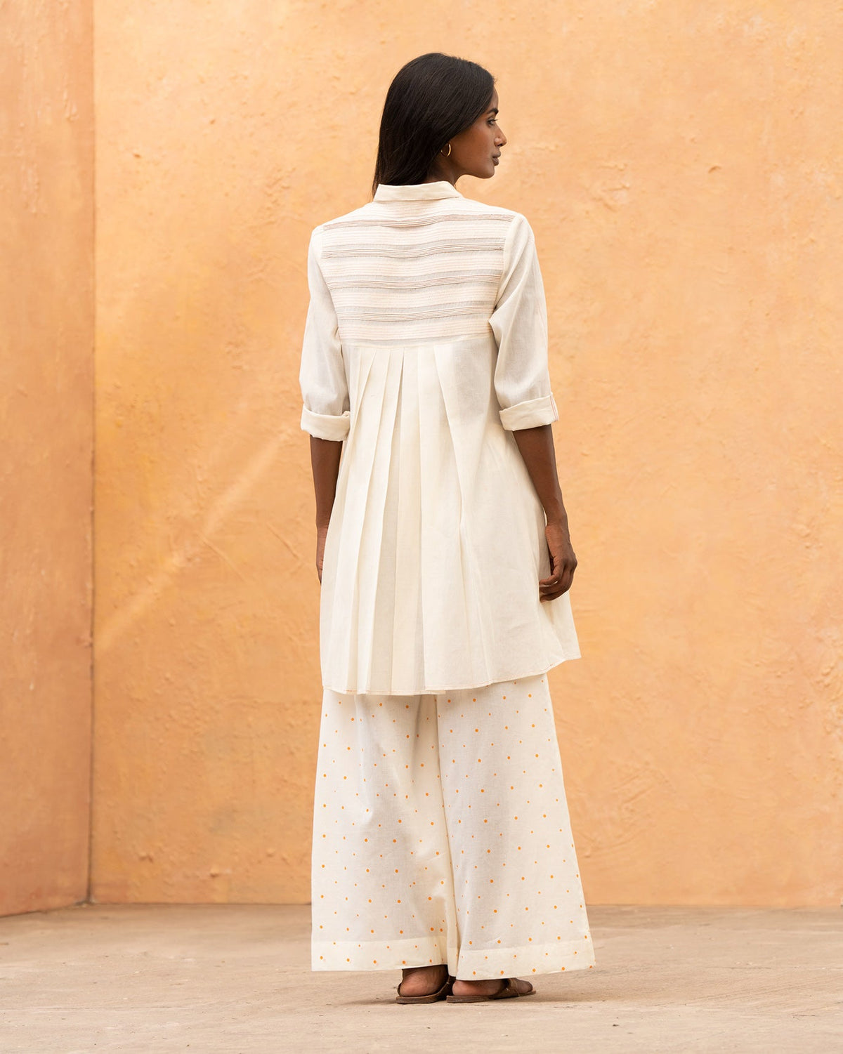 Back of an ivory Back Flayer Top with pleats below the yoke.