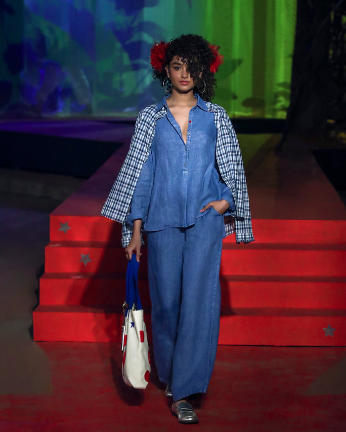 Person wearing a blue Mati shirt set with matching trousers.