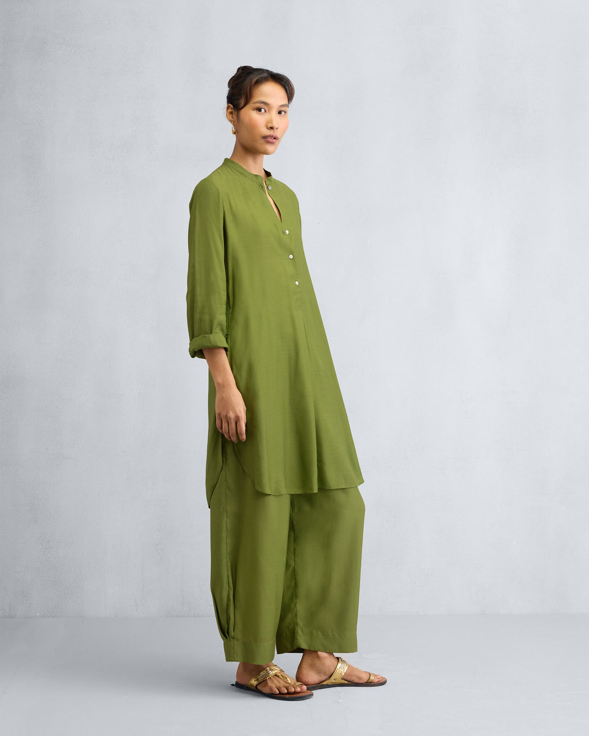 Three-quarter view of an olive mid-length kurta set with matching pants.