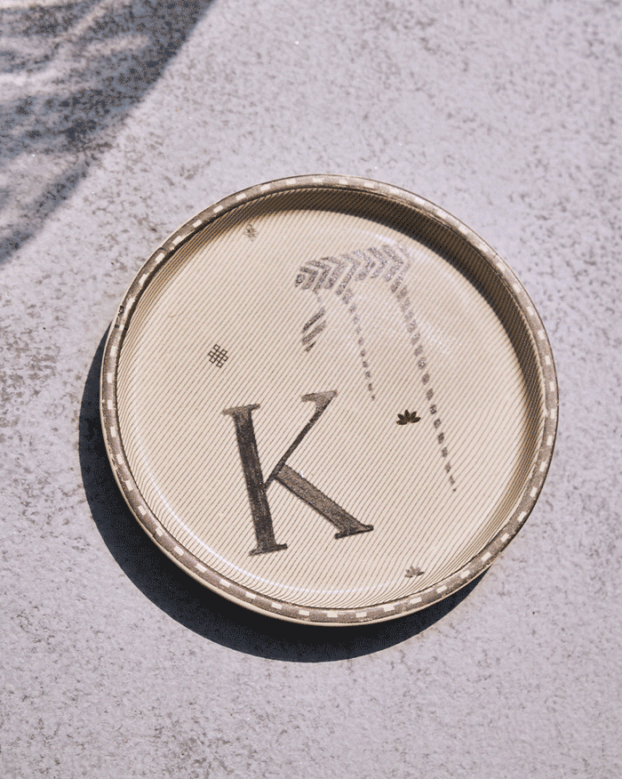 Round Akshar alphabet coasters cycling through letter designs.