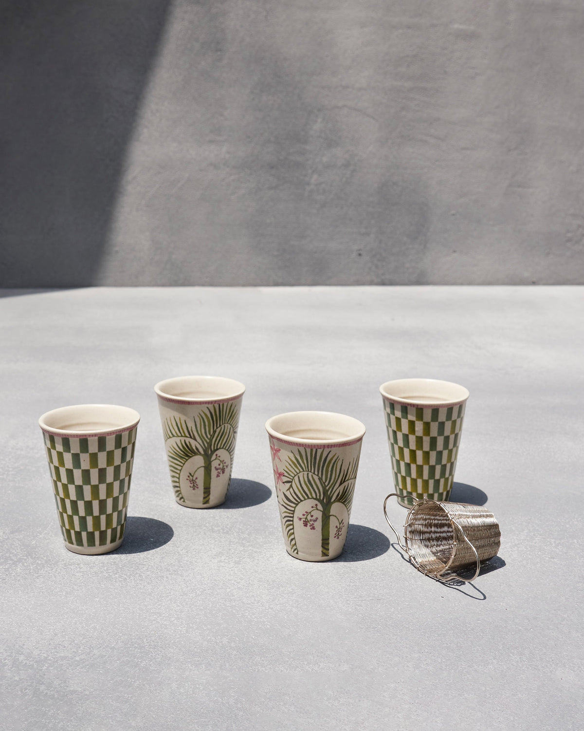 Close-up of Oyster Bay kulhar cups showing palm and checkered designs.