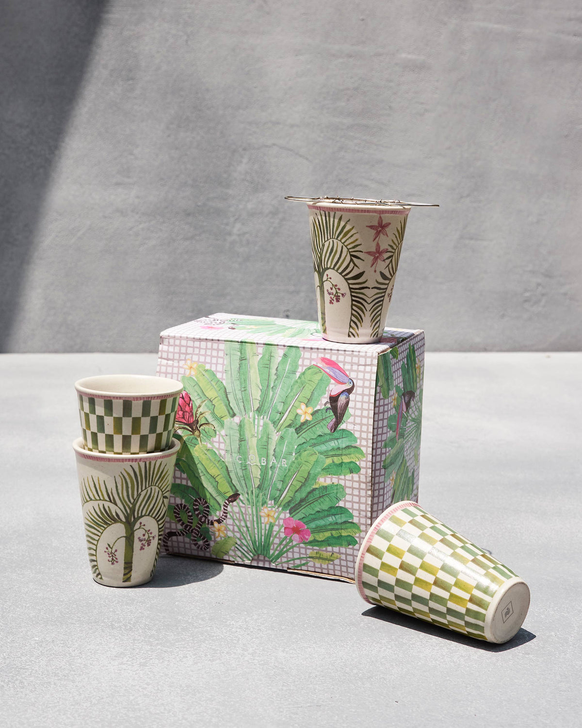 Oyster Bay kulhar and strainer set with cups in front of its printed box.