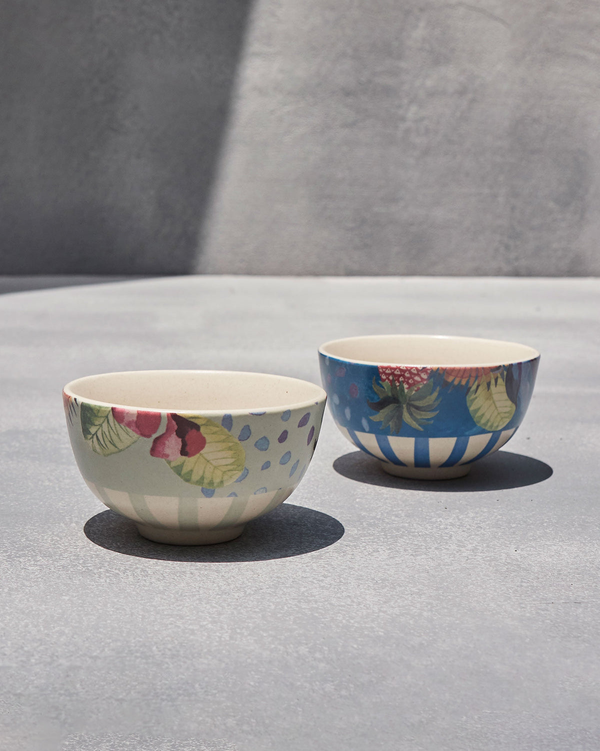 Pair of Mahi nibble bowls side by side, one blue and one pale grey-green.