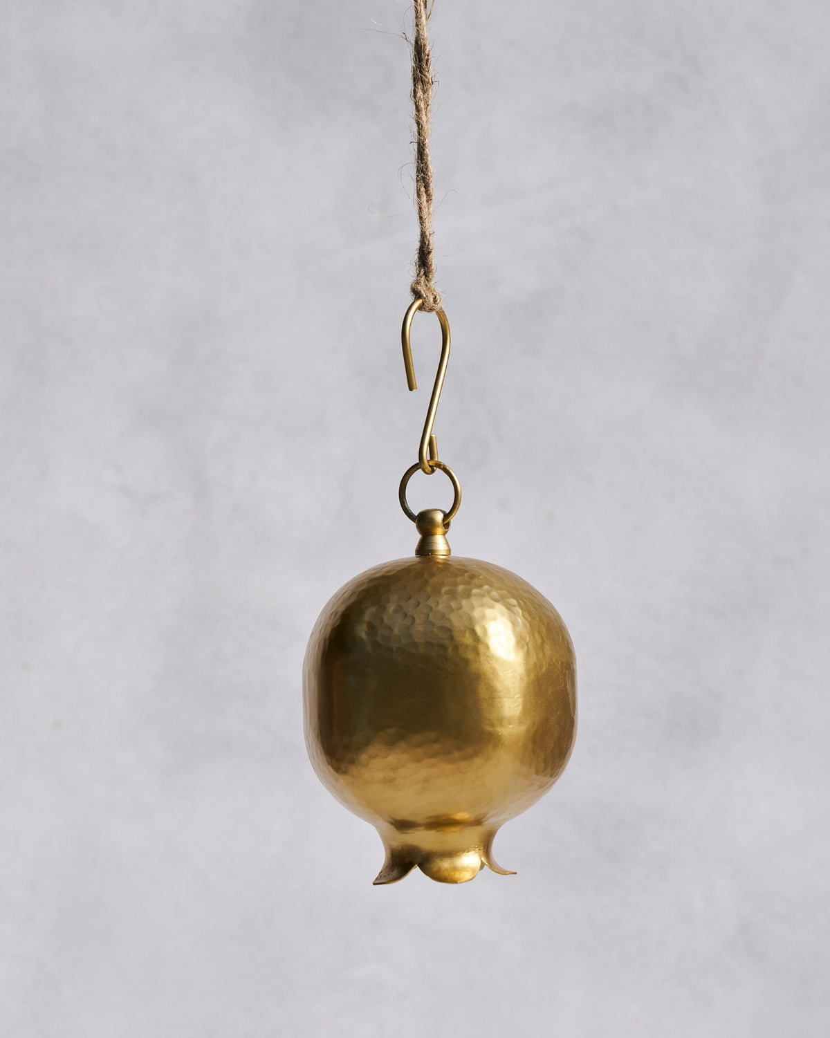 Hammered gold Anar bell shaped like a pomegranate on a hanging hook.