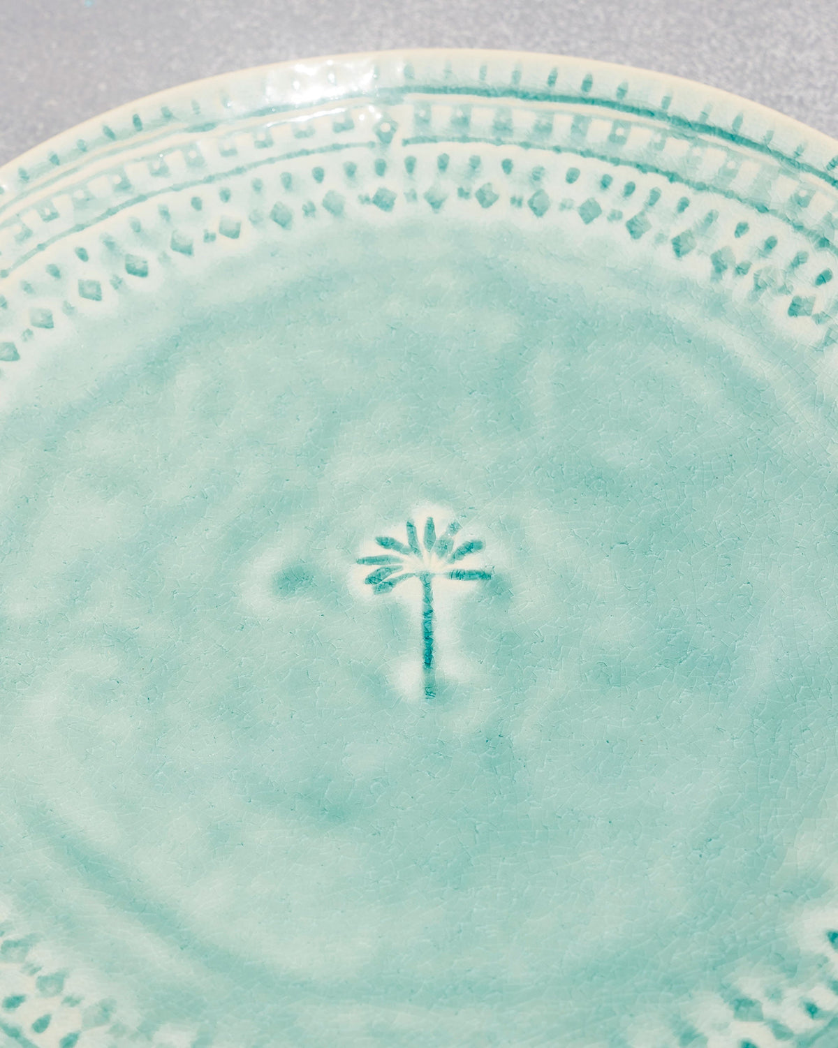 Close-up of Coco Palm Dinner Plate showing its palm motif in the centre.