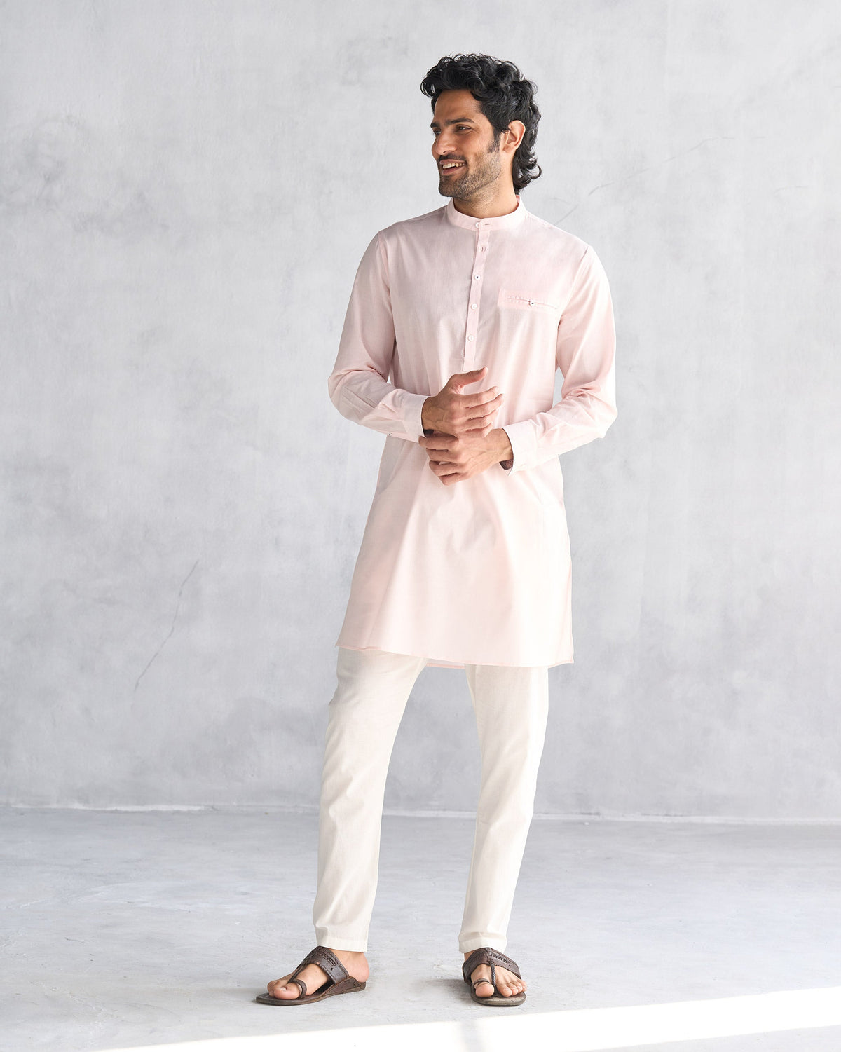 Person wearing a pink Pondicherry kurta with mandarin collar and chest pocket.