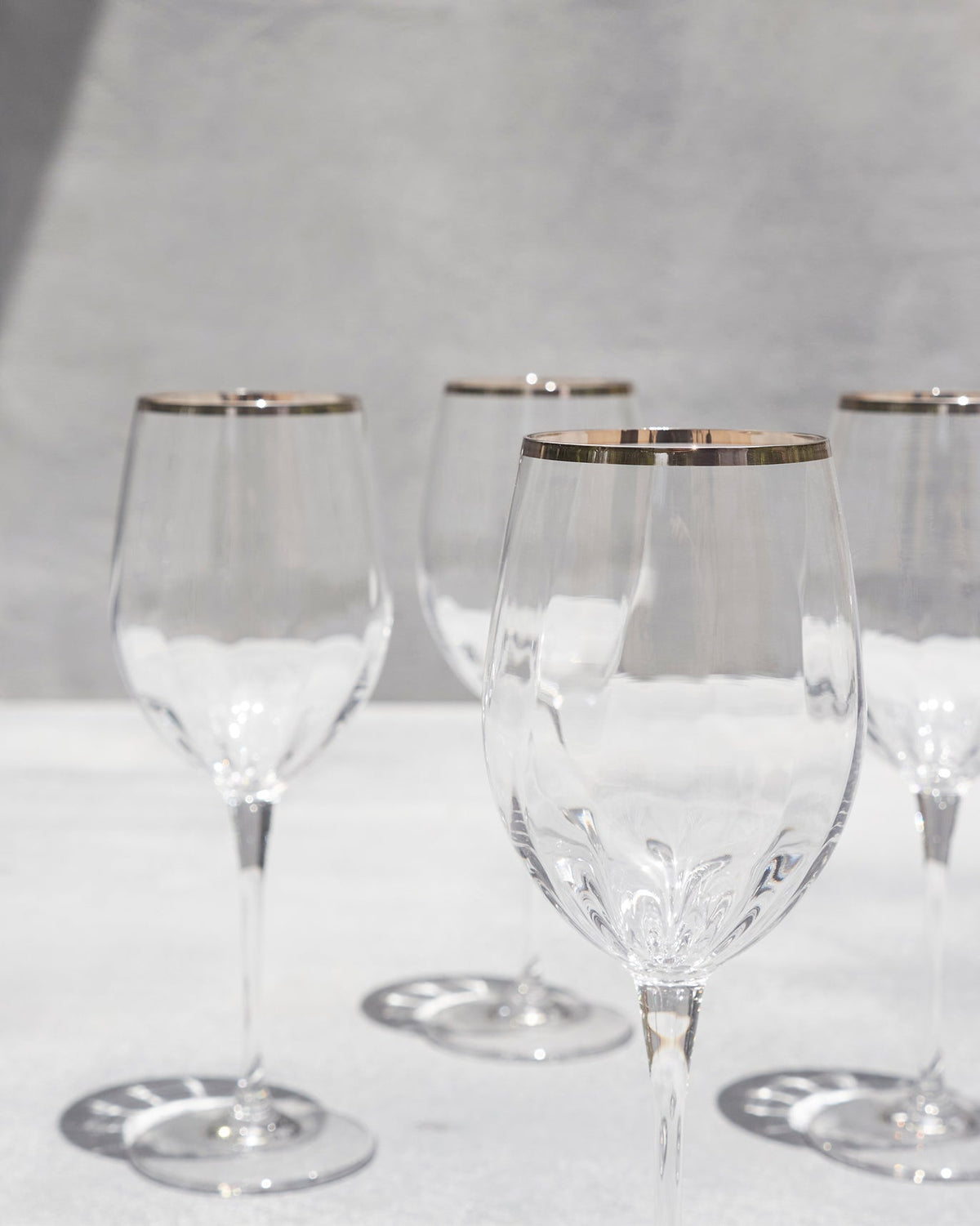 Close-up of Celeste red wine glasses with ridged bowls and metallic rims.