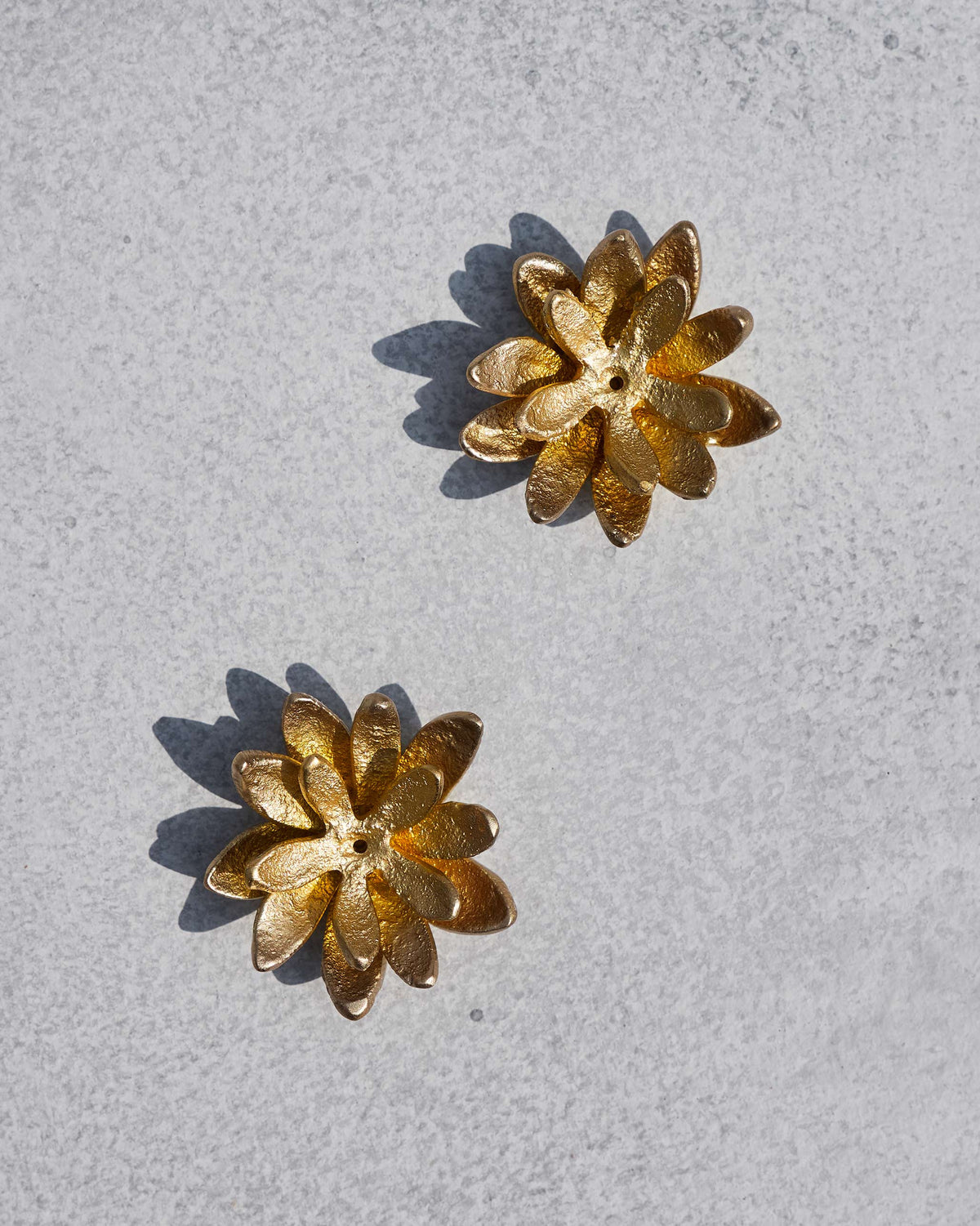 Pair of Kamal gold lotus incense holders showing center stick holes.
