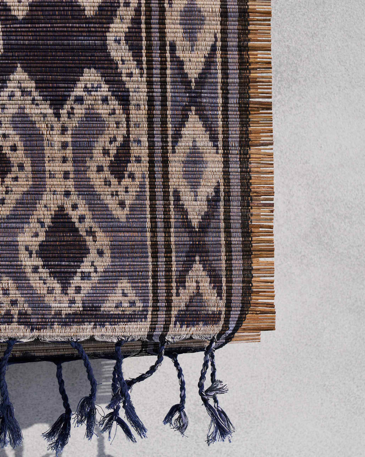 Close-up of a Sitara Ikat Runner showing its navy tassels and woven edge.