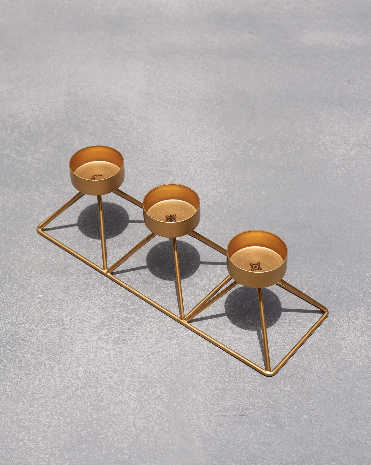 Angled view of Myra Tealight Stand with small motifs inside each cup.