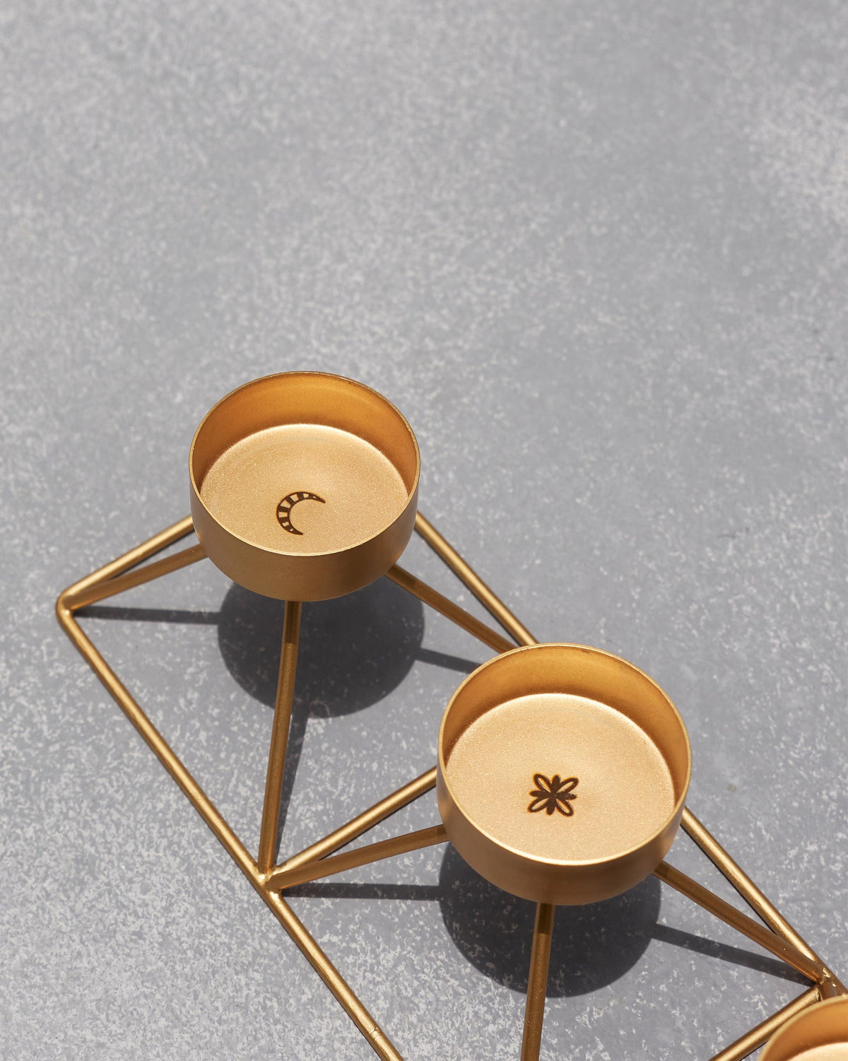 Close-up of Myra Tealight Stand cups showing a moon and flower motif.