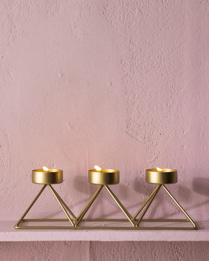 Myra Tealight Stand with three lit tealights in a row.