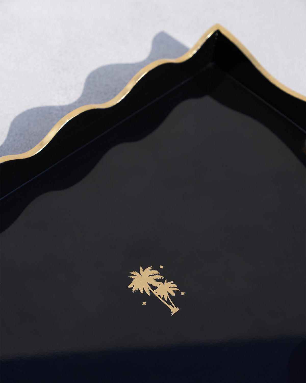 Close-up of the Twilight Tray showing its gold palm tree motif on black.